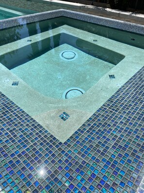 Una piscina con borde de azulejos y desagüe central.