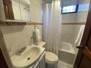 A bathroom with a sink, toilet, and bathtub.
