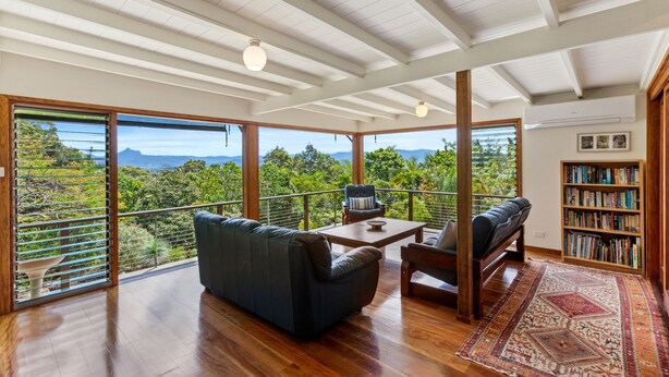 A spacious room with a large window, a sofa, a chair, a coffee table, and a bookshelf. - Farrants Hill (Farrants Hill)