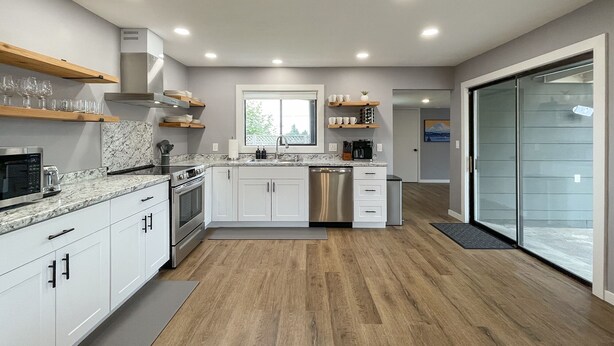 A modern kitchen with white cabinets, a granite countertop, and stainless steel appliances. - Excellent location, close to Olympic National Park, restaurants & grocery stores (Port Angeles)