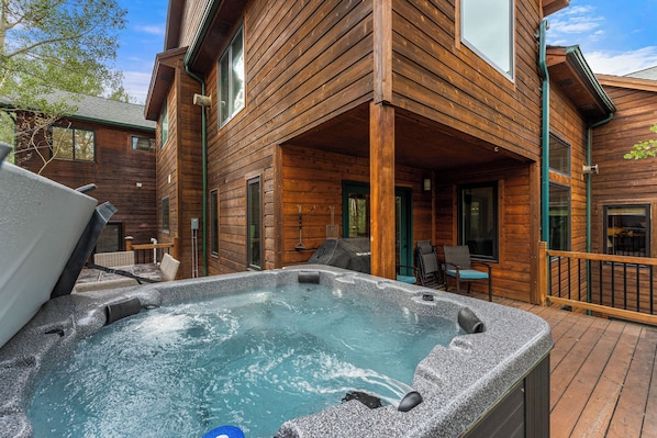 Uma cabana de madeira com banheira de hidromassagem e área de estar externa.