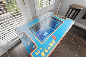 Une borne d’arcade portant l’inscription « Arcade des années 80 », dotée d’un écran numérique, de boutons et d’un joystick.