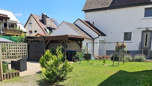 Ett bostadsområde med en asfalterad uppfart, en liten gräsmatta och ett trästaket.