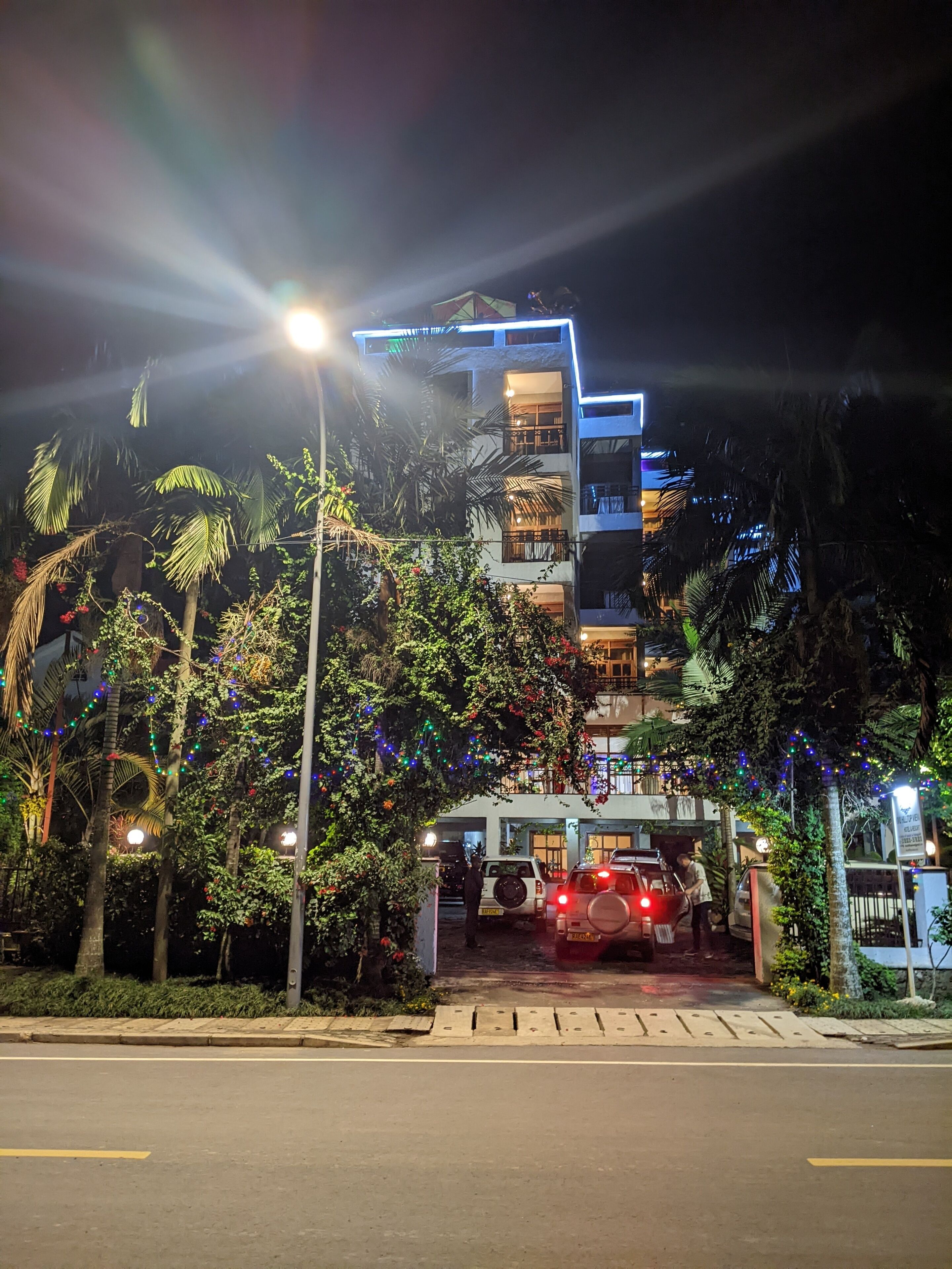 A multi-story hotel with a modern design, featuring balconies and a well-lit entrance.