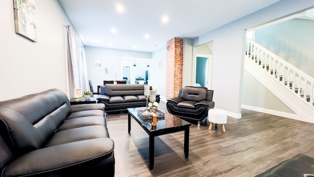 Een moderne woonkamer met een hoekbank, een salontafel en een open haard.