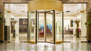 Una puerta giratoria con paneles de vidrio en un vestíbulo.