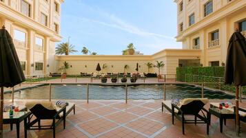 Alberca al aire libre, sombrillas en la alberca y camastros