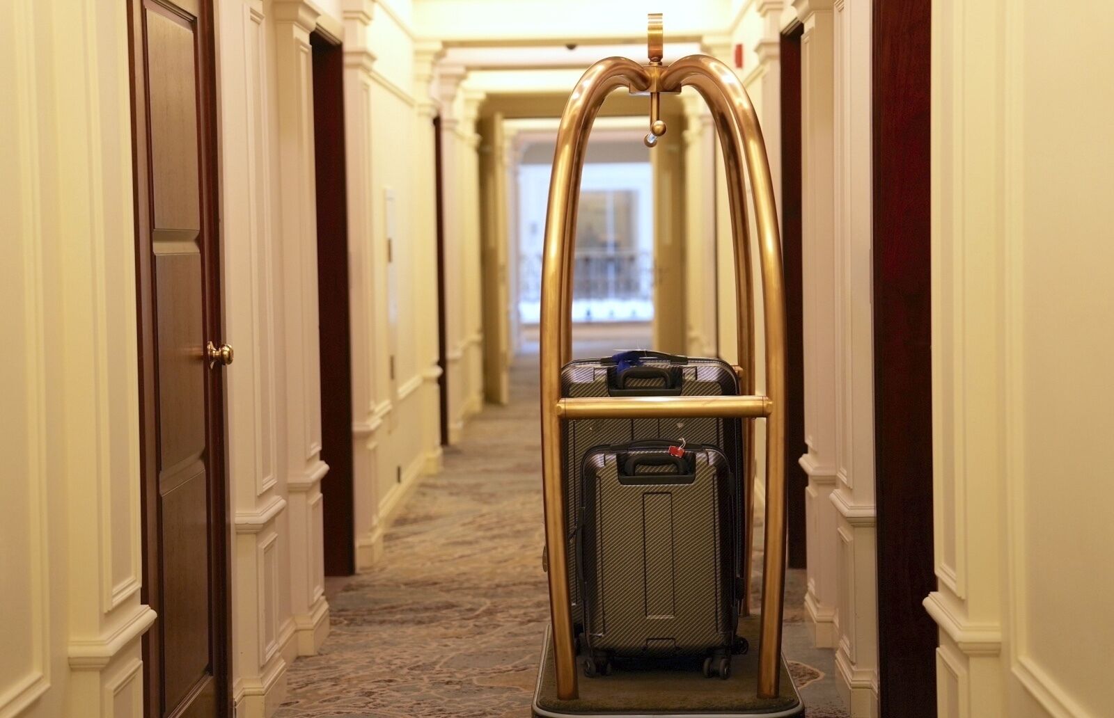 Een hotelgang met een bagagewagen.