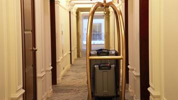 Een hotelgang met een bagagewagen.