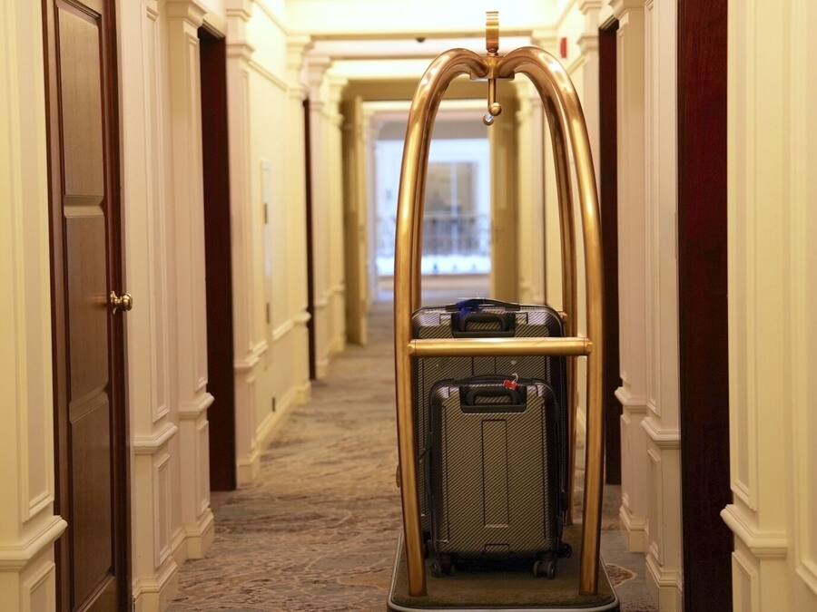 Een hotelgang met een bagagewagen.