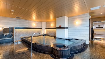 A modern spa area with a hot tub, a digital clock, and a reception desk.