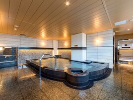 A modern spa area with a hot tub, a digital clock, and a reception desk.