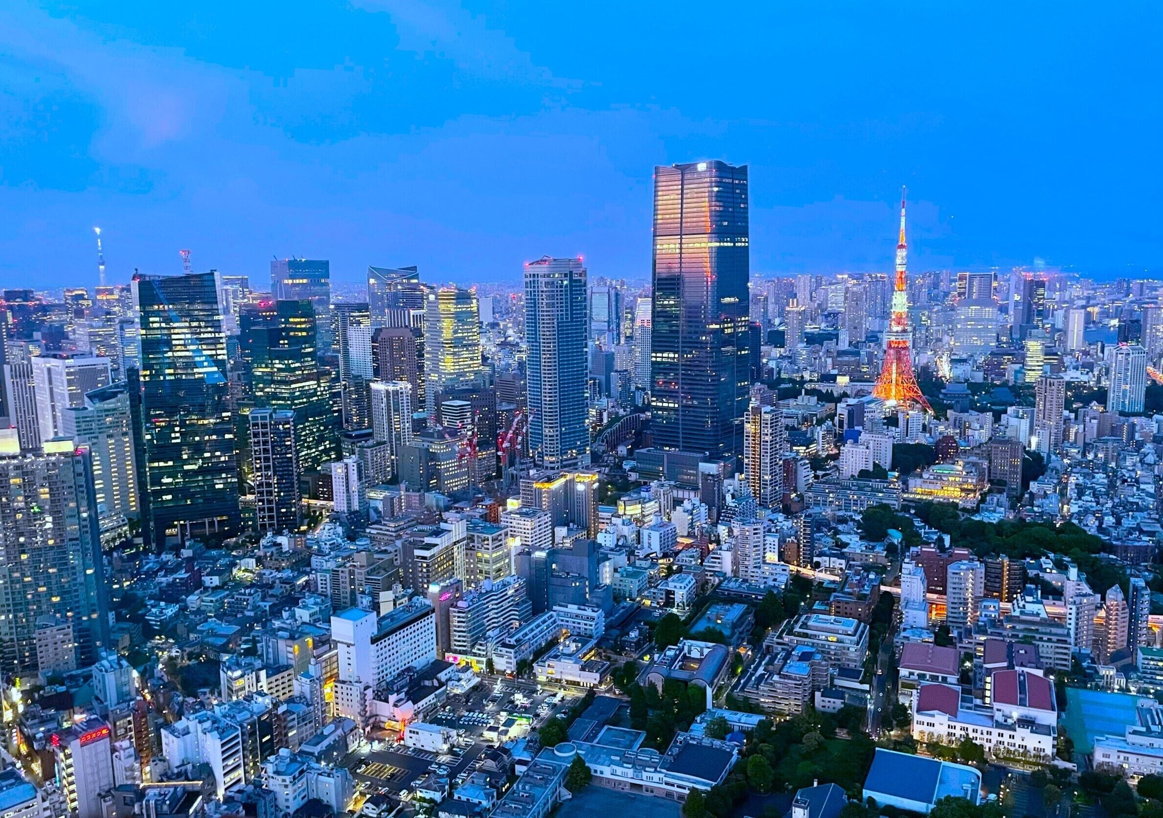 A cityscape with high-rise buildings and a prominent tower with lights.
