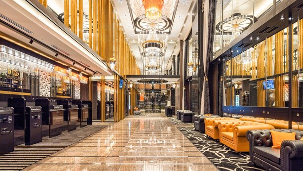A spacious hotel lobby with a long corridor, chandeliers, and leather seating areas. - APA Hotel & Resort Roppongi Ekihigashi (Tokyo)