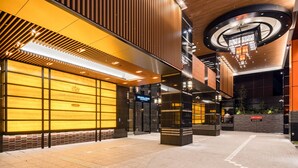 A modern hotel lobby with a wooden facade, a circular skylight, and a sign indicating the exit. - APA Hotel & Resort Roppongi Ekihigashi (Tokyo)