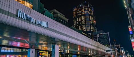 Un edificio moderno con un letrero llamativo que dice 'Roppongi Roppongi'.