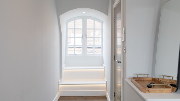 Uma casa de banho moderna com uma janela ampla, um tabuleiro de madeira e um espelho.