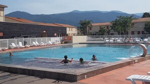 Ein Schwimmbecken mit Liegestühlen und Blick auf die Berge.