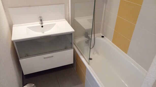 Ein Badezimmer mit einem weißen Waschbecken, einer Duschkabine und einer Badewanne.