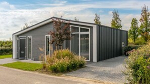 Un bâtiment moderne, de plain-pied, avec une façade grise et de grandes fenêtres.