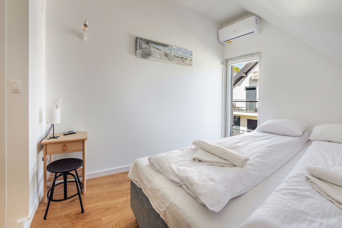 A bedroom with a bed, a desk, and a chair.