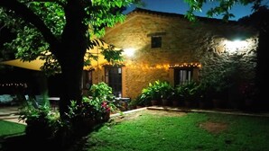 A stone building with a well-maintained lawn and potted plants.