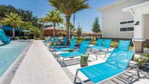 A pool area with lounge chairs and a water slide. - The Secret to Enjoying Your Luxury Villa Holiday on Veranda Palms Resort, Orlando Villa 5550 (Kissimmee)