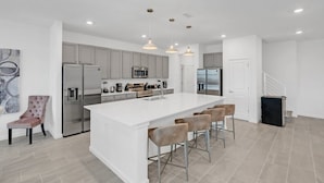 A modern kitchen with a central island, stainless steel appliances, and pendant lighting. - Imagine Your Family Renting This Luxury Contemporary Style Mansion on Veranda Palms Resort Orlando Mansion 5546 (Kissimmee)