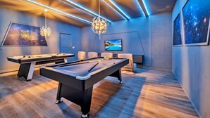 A modern room with a pool table, two comfortable chairs, a TV, and a starry night wall art. - Your Beautiful 5 Star Villa Minutes From Disney on the Prestigious Windsor Island Resort, Orlando Villa 5566 (Kissimmee)