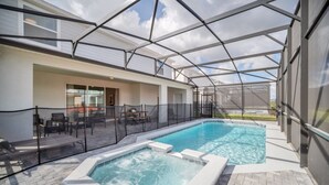 An indoor swimming pool with a glass enclosure, seating area, and a hot tub. - Your Beautiful 5 Star Villa Minutes From Disney on the Prestigious Windsor Island Resort, Orlando Villa 5566 (Kissimmee)