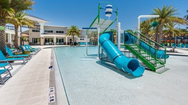 A swimming pool with a blue slide, lounge chairs, and palm trees. - Amazing Villa on Veranda Palms Resort With Private Pool, Orlando Villa 5626 (Kissimmee)