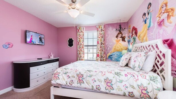A pink-themed bedroom with a bed, dresser, and a ceiling fan. - Luxury 8 Bedroom Mansion on Champions Gate Resort, Orlando Mansion 5642 (Davenport)