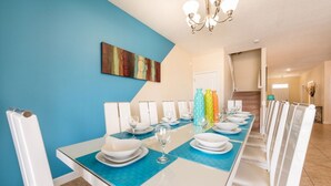 A dining area with a long table set for a meal, blue walls, and a chandelier. - Luxury 8 Bedroom Mansion on Champions Gate Resort, Orlando Mansion 5642 (Davenport)