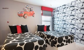 A bedroom with two beds, each with a cow print bedspread, a Mickey Mouse wall decal, and a red car decal. - Luxury 8 Bedroom Mansion on Champions Gate Resort, Orlando Mansion 5642 (Davenport)