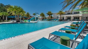 A swimming pool with lounge chairs and palm trees. - Spacious 12 Bedroom Oasis 5649 (Kissimmee)