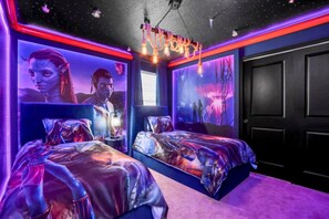Ein Schlafzimmer mit zwei Betten, einer Sternenhimmel-Decke und lebendigen Wandbildern.