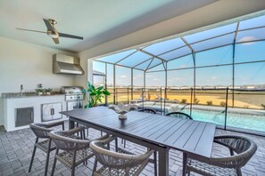 Ein geräumiger Balkon mit Blick auf eine Wüstenlandschaft, inklusive Grill und Pool.