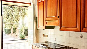 Una cucina con mobili in legno, un piano di lavoro in granito e una finestra vista giardino.