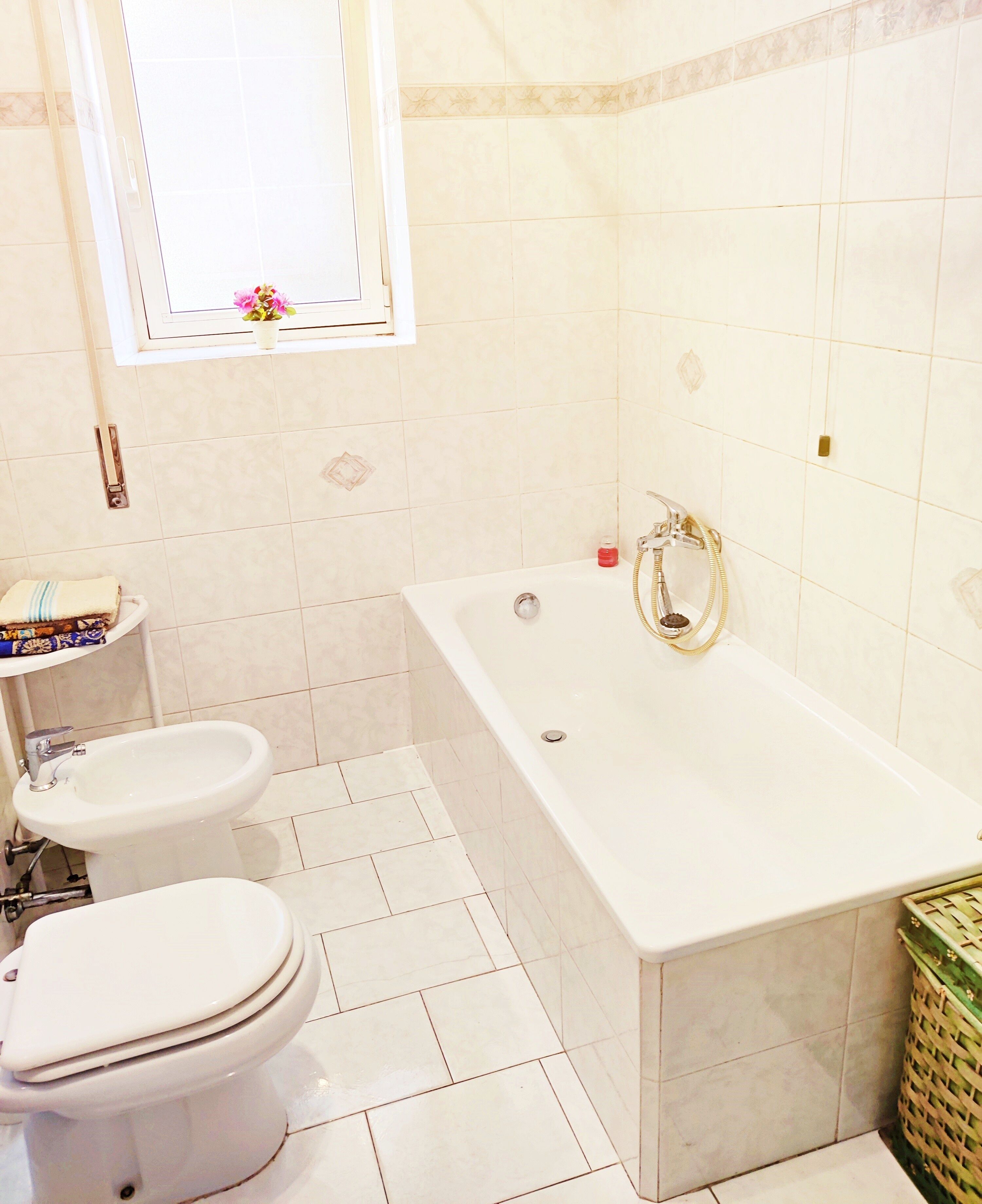 A bathroom with a bathtub, toilet, and bidet.