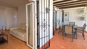 Una sala de estar con un sofá, una mesa de centro y una zona de comedor con sillas y una mesa.