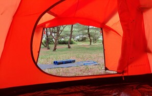 Una carpa roja con vistas a un área verde y árboles.