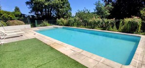 A rectangular swimming pool with a tiled edge, surrounded by a grassy area and a metal fence. - Creuse, Large character house in quiet area with terrace, swim. pool and garden (Auzances)
