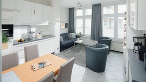 A modern apartment with a kitchen, dining area, and living space. - // REGINA MARIS - APARTMENT 1 // (Norderney)