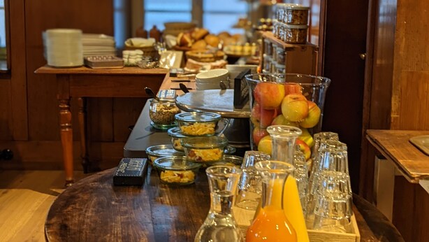 A breakfast buffet with various food items and beverages on a wooden table. - Hotel Bären (Marbach am Neckar)