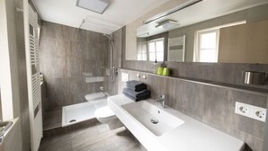 A modern bathroom with a bathtub, toilet, and shower. - Hotel Bären (Marbach am Neckar)