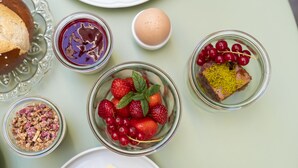 A table with various food items including strawberries, cherries, a slice of cake, and a bowl of granola. - Hotel Bären (Marbach am Neckar)