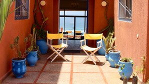 An outdoor seating area with two yellow chairs and potted plants. - Charming villa facing the sea. (province chtouka Ait Baha)
