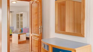 A room with a wooden wardrobe, a small table, and a mirror on the wall. - Holiday Home 'Cottage Santa Lucía 1' with Terrace, Shared Garden & Wi-Fi (Santa Lucía de Tirajana)