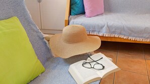 A room with a bed, a chair, a hat, glasses, and an open book. - Holiday Home 'Cottage Santa Lucía 1' with Terrace, Shared Garden & Wi-Fi (Santa Lucía de Tirajana)