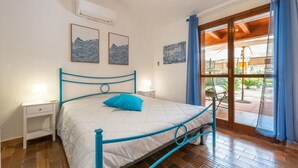 A bedroom with a bed, bedside tables, and artwork on the walls. - Holiday Home 'Villetta Pineta' with Private Garden (Santa Margherita di Pula)